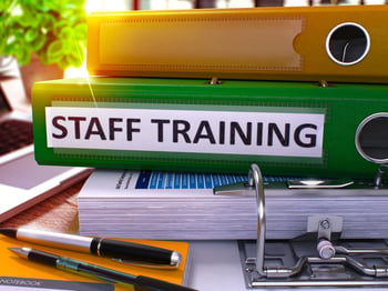 Staff Training - Green Office Folder on Background of Working Table with Stationery and Laptop. Staff Training Business Concept on Blurred Background. Staff Training Toned Image. 3D.